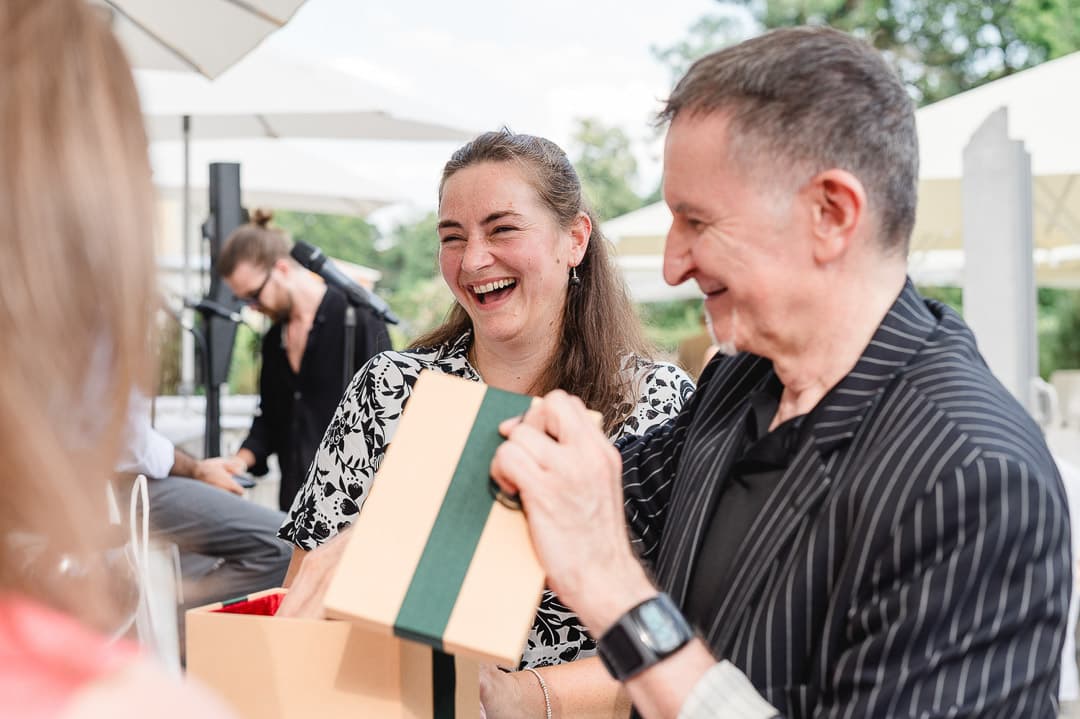 Alleinunterhalter und Zauberer Michi zaubert mit einem Geschenk an einem Tisch auf einer Feier in München
