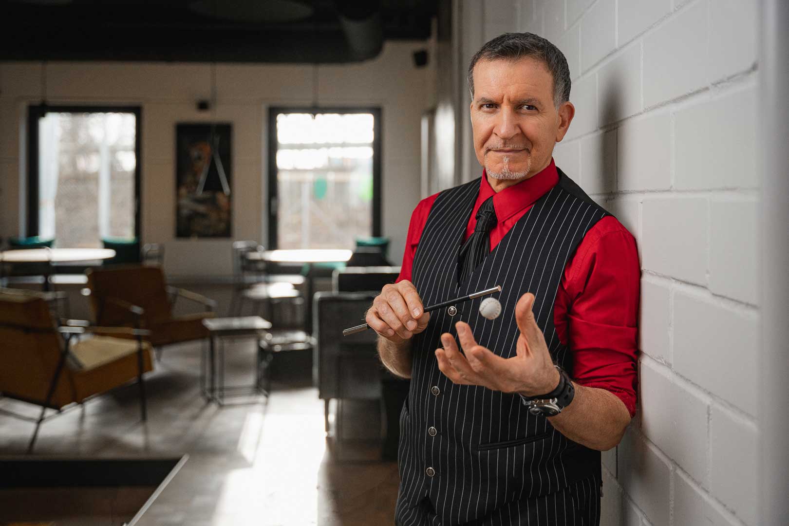 Alleinunterhalter und Zauberer Michi zaubert mit einem Geschenk an einem Tisch auf einer Feier in München