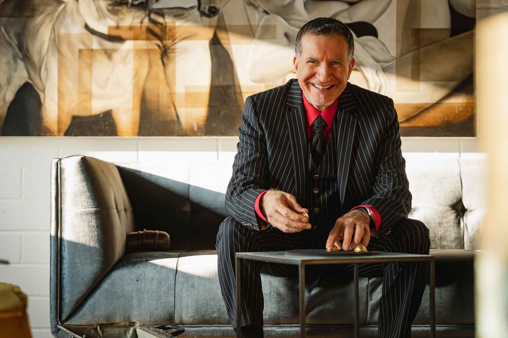 Michi, der Zauberer aus München sitzt auf einem gemütlichen Sofa und zaubert