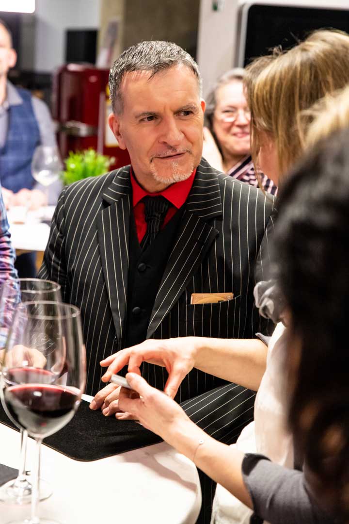 Michi sitzt am Tisch und ist im Gespräch mit Gästen